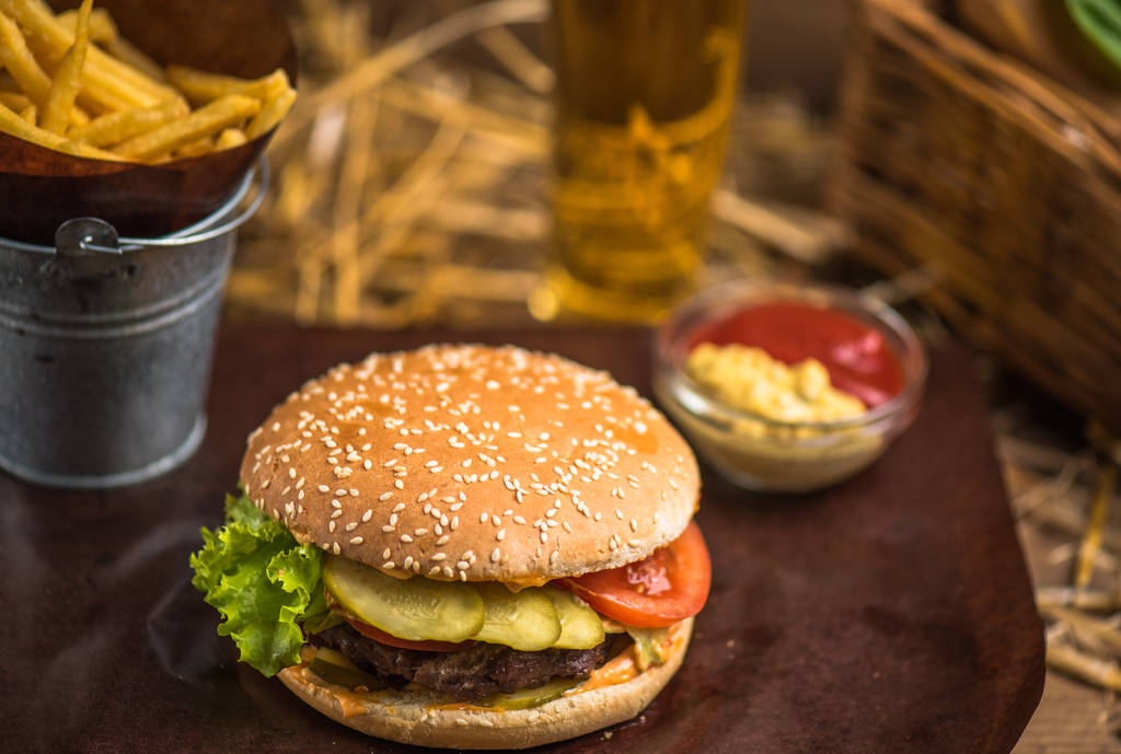 Hamburger gustoso con patatine fritte su tavola di legno
 - Foto, immagini