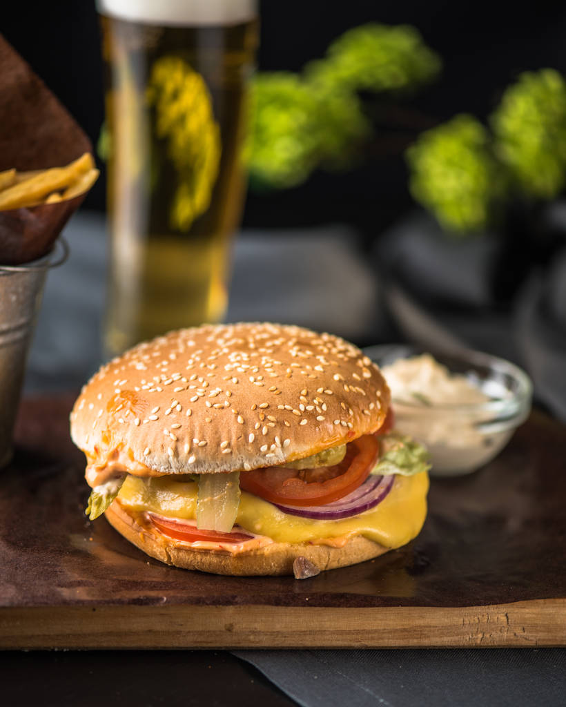 Hamburger savoureux avec frites sur planche de bois
 - Photo, image
