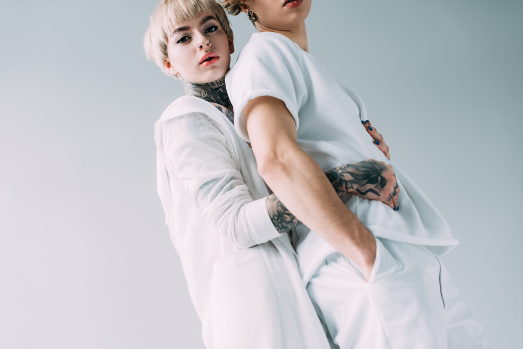 bionda fidanzata con tatuaggi abbracciare fidanzato isolato su grigio
 - Foto, immagini