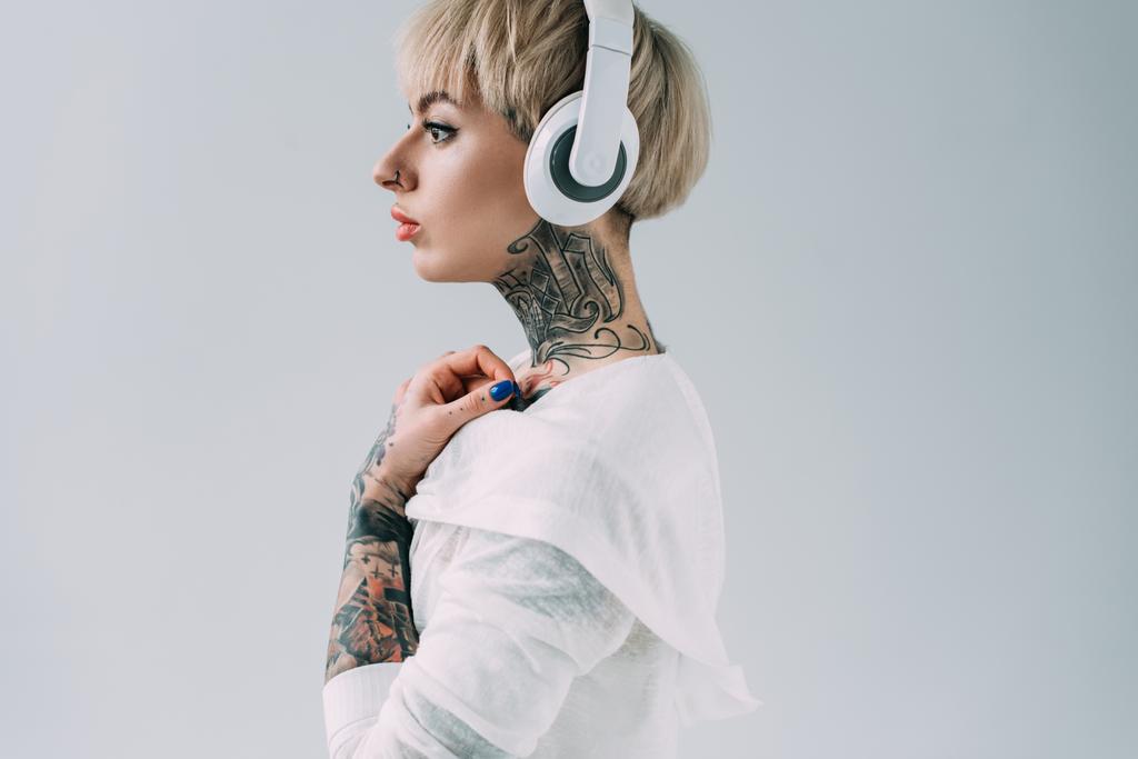 вид сбоку привлекательной женщины, слушающей музыку в наушниках, изолированных на сером фоне
  - Фото, изображение