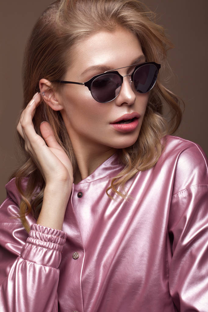 Красивая девушка в стильной розовой одежде с солнечными очками и сексуальными губами
. - Фото, изображение