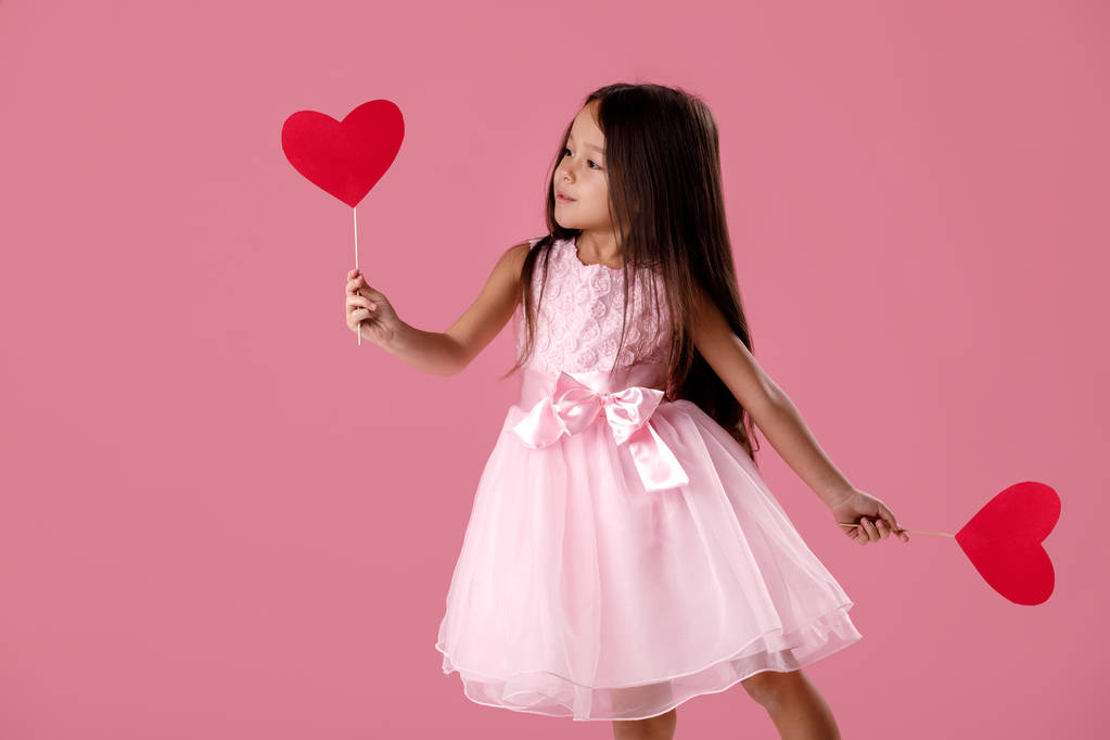söpö pieni tyttö vaaleanpunainen mekko tilalla paperi sydän
 - Valokuva, kuva