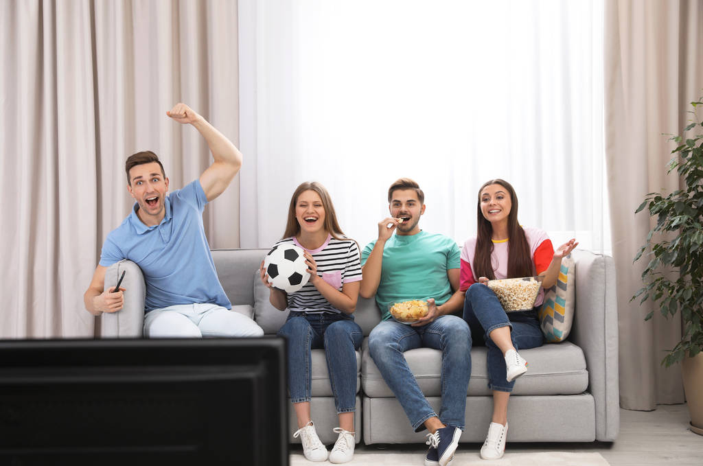 Grupa ludzi oglądania telewizji razem na kanapie w salonie. Miejsca na tekst - Zdjęcie, obraz