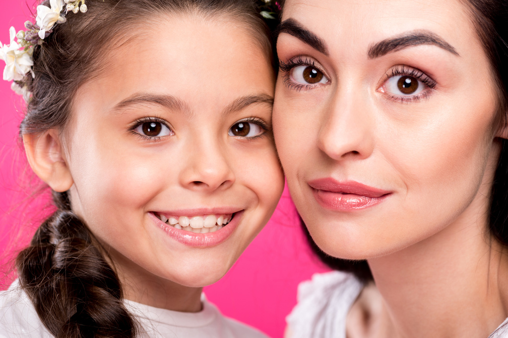 close-up retrato de bela mãe feliz e filha sorrindo para a câmera isolada em rosa
 - Foto, Imagem