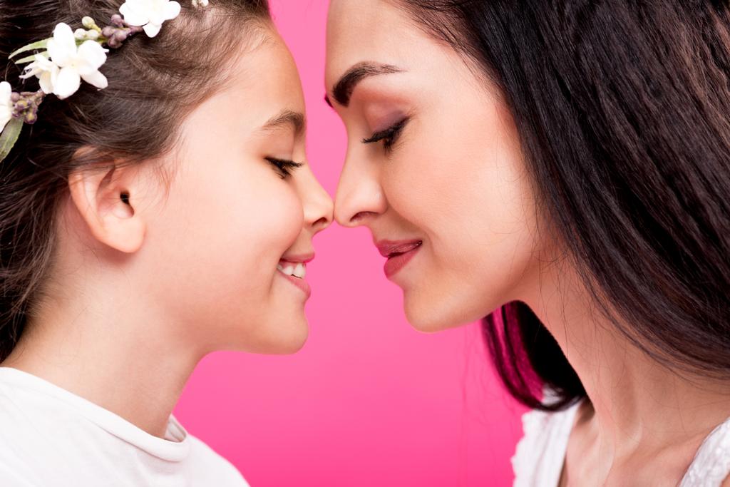 Seitenansicht der schönen glücklichen Mutter und Tochter isoliert auf rosa - Foto, Bild