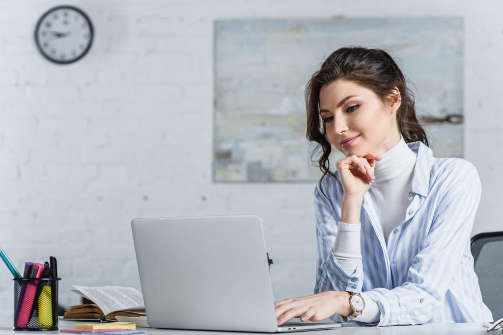 Attraente donna d'affari che guarda lo schermo del computer portatile al lavoro
 - Foto, immagini
