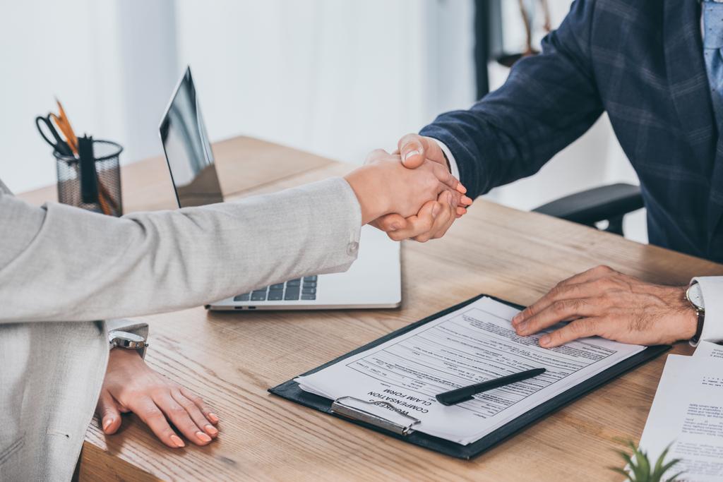 cropped view of shaking hands businessman and woman over table in office, compensation concept - Photo, Image