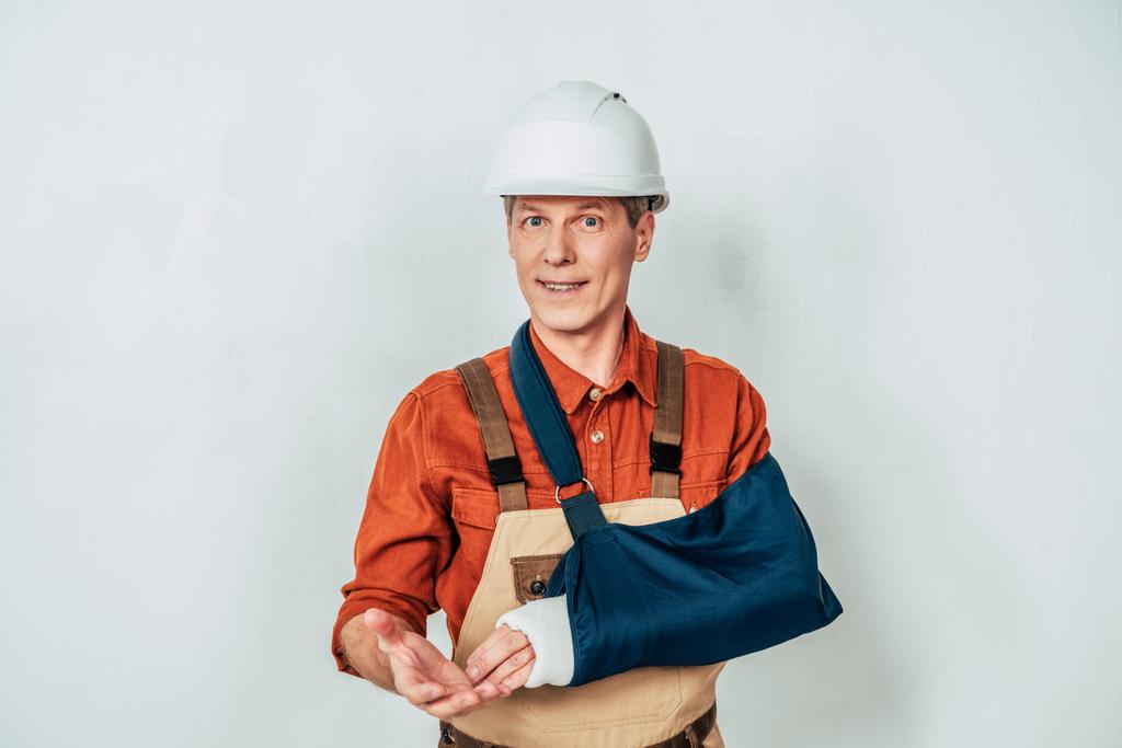 reparador con vendaje de brazo de pie sobre fondo blanco
 - Foto, imagen