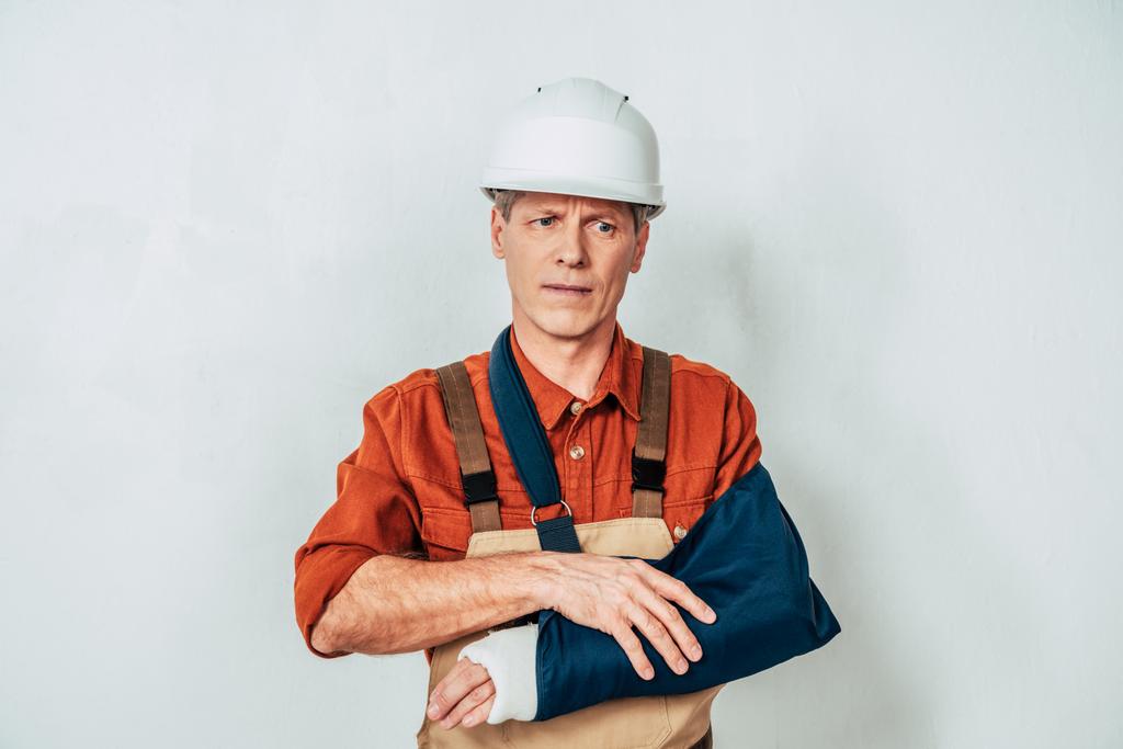 reparador con vendaje de pie y brazo de sujeción sobre fondo blanco
 - Foto, imagen