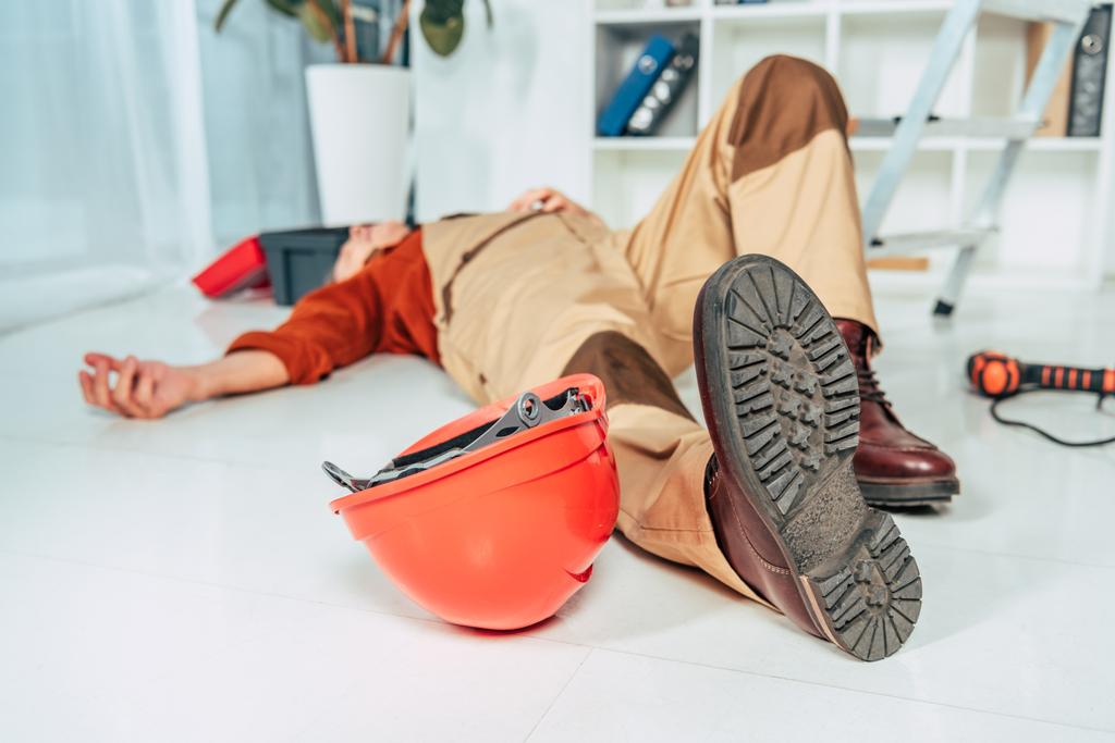 repairman lying on white floor in uniform in office - Photo, Image