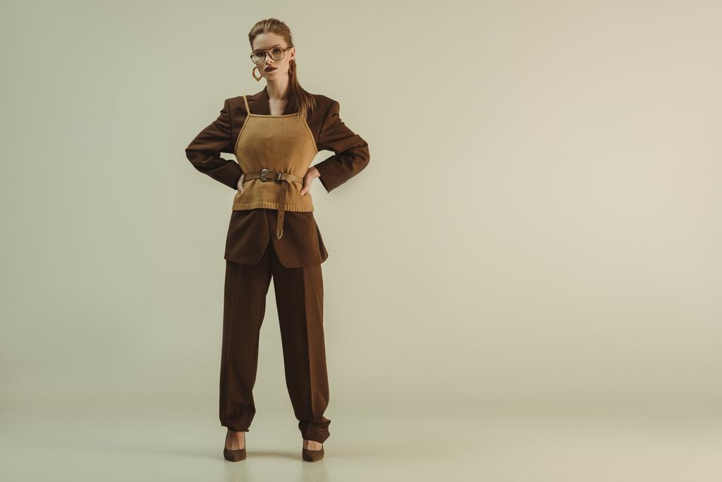 модная девушка позирует в модной ретро-одежде на бежевом
 - Фото, изображение
