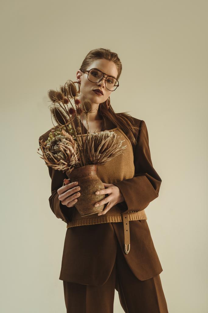 kil sürahisi ile buket üzerinde bej izole kuru tutarak vintage tarzı çekici moda kız - Fotoğraf, Görsel