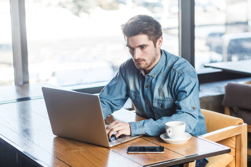 Portret van succesvolle ernstige bebaarde zakenman, werken op computer zittend in café  - Foto, afbeelding