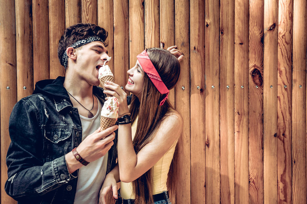 Couple having fun together. The girl jokingly smeared ice cream to her friend in the face. They laugh together. - Photo, Image
