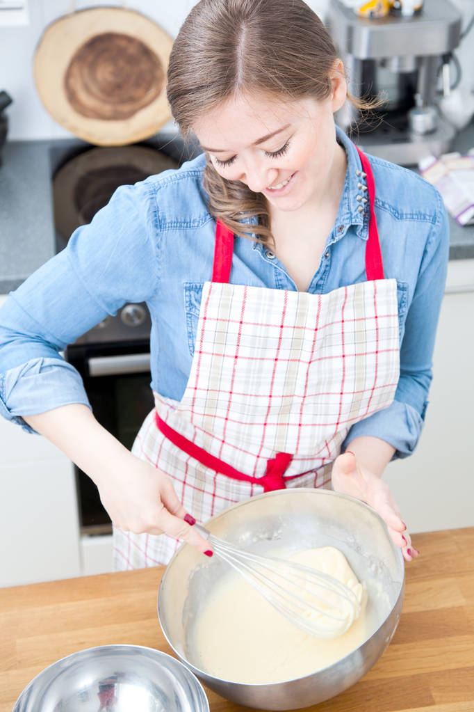 güzel gülümseyen genç kadın mutfakta hamur hazırlama önlük  - Fotoğraf, Görsel