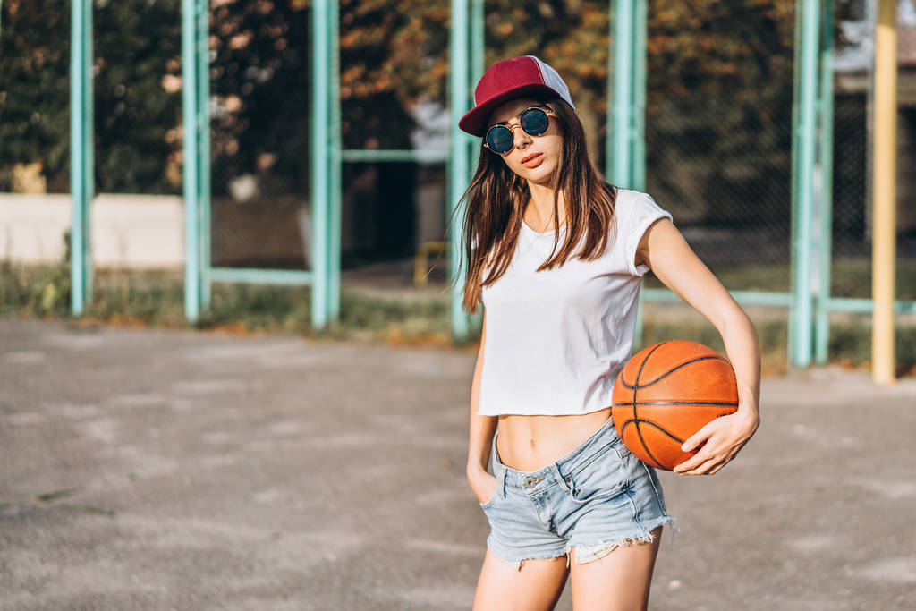 Bastante joven chica deportiva con pelota de baloncesto al aire libre
 - Foto, imagen