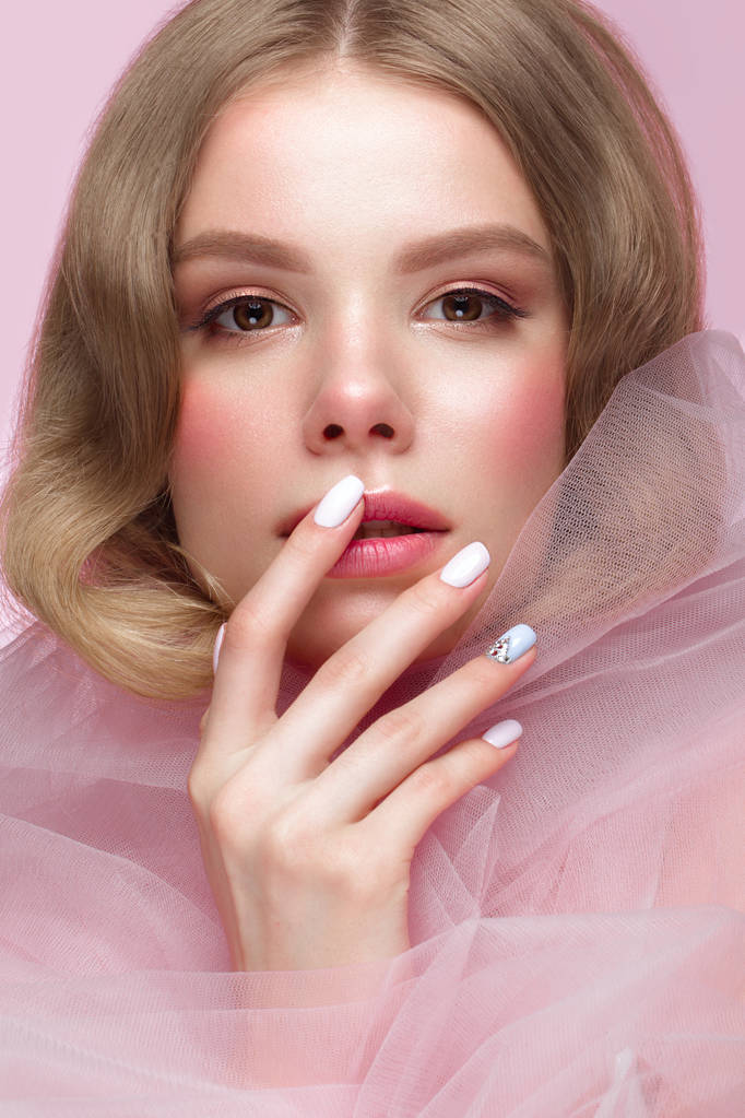 Mooi meisje met lichte make-up en zachte manicure in roze kleding. Het gezicht van de schoonheid. Design nagels. - Foto, afbeelding