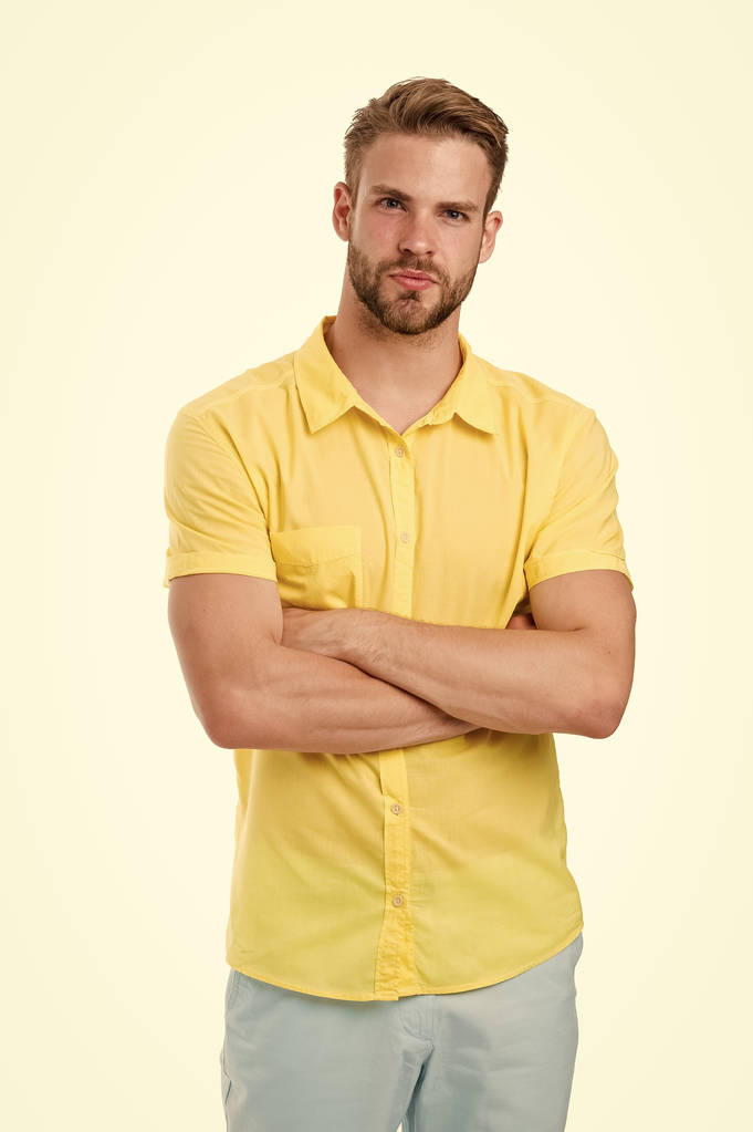 Sakin yüzlü, kolları katlanmış, beyaz arka planı olan bir adam. Adam sarı keten gömlekle çekici görünüyor. Tüylü adam rahat ya da resmi gömlek giyiyor. Moda konsepti - Fotoğraf, Görsel