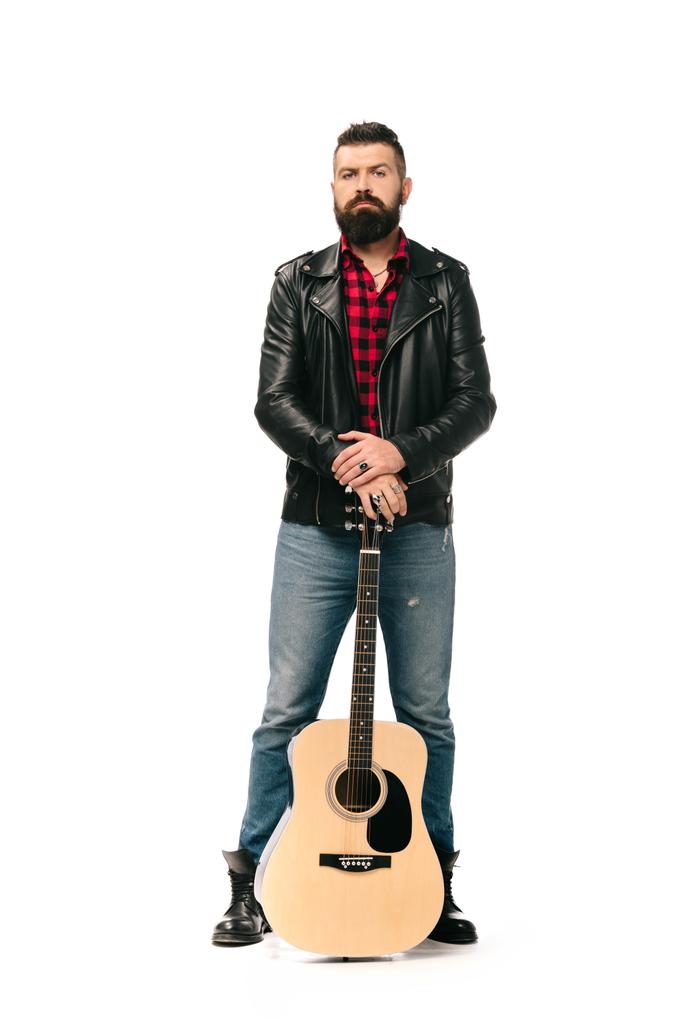 handsome rocker in black leather jacket posing with acoustic guitar, isolated on white - Photo, Image