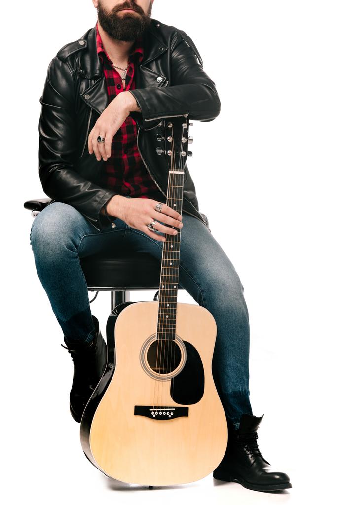 アコースティック ギターは、白で隔離したポージングと黒い革のジャケットでミュージシャンのトリミング ビュー - 写真・画像