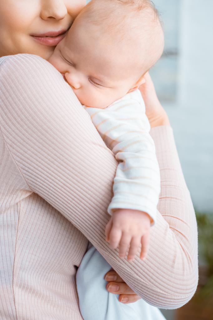 recortado disparo de feliz joven madre llevando adorable durmiendo bebé
  - Foto, Imagen
