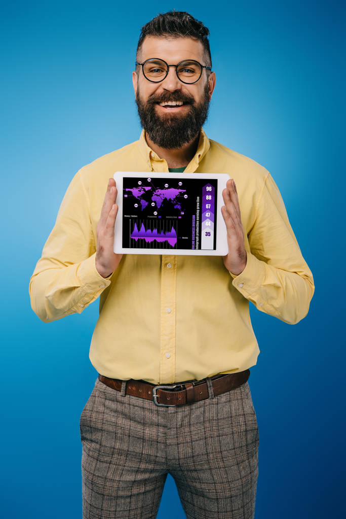 Улыбающийся бородатый мужчина представляет цифровой планшет с инфографикой, изолированный на голубом
 - Фото, изображение