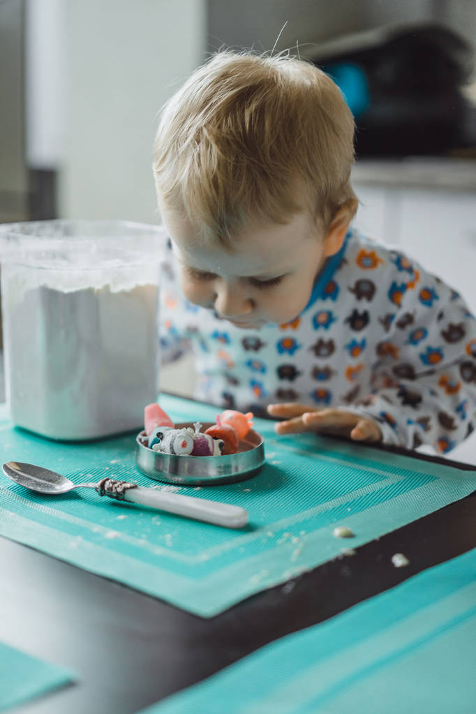 chłopiec dziecko w piżamie rano z mama gotowanie szarlotka w kuchni i zabawy z zabawkami - Zdjęcie, obraz