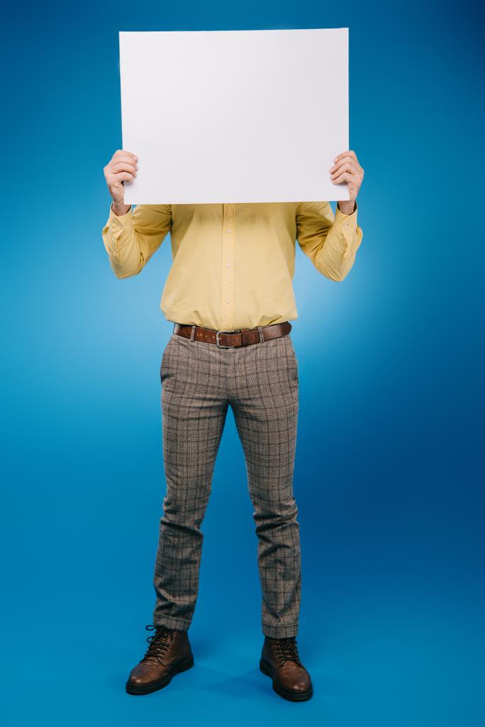 hombre sosteniendo pancarta en blanco aislado en azul
 - Foto, imagen