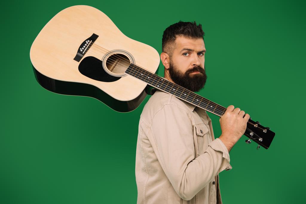 Akustik gitar, yeşil izole tutan erkek gitarist sakallı - Fotoğraf, Görsel