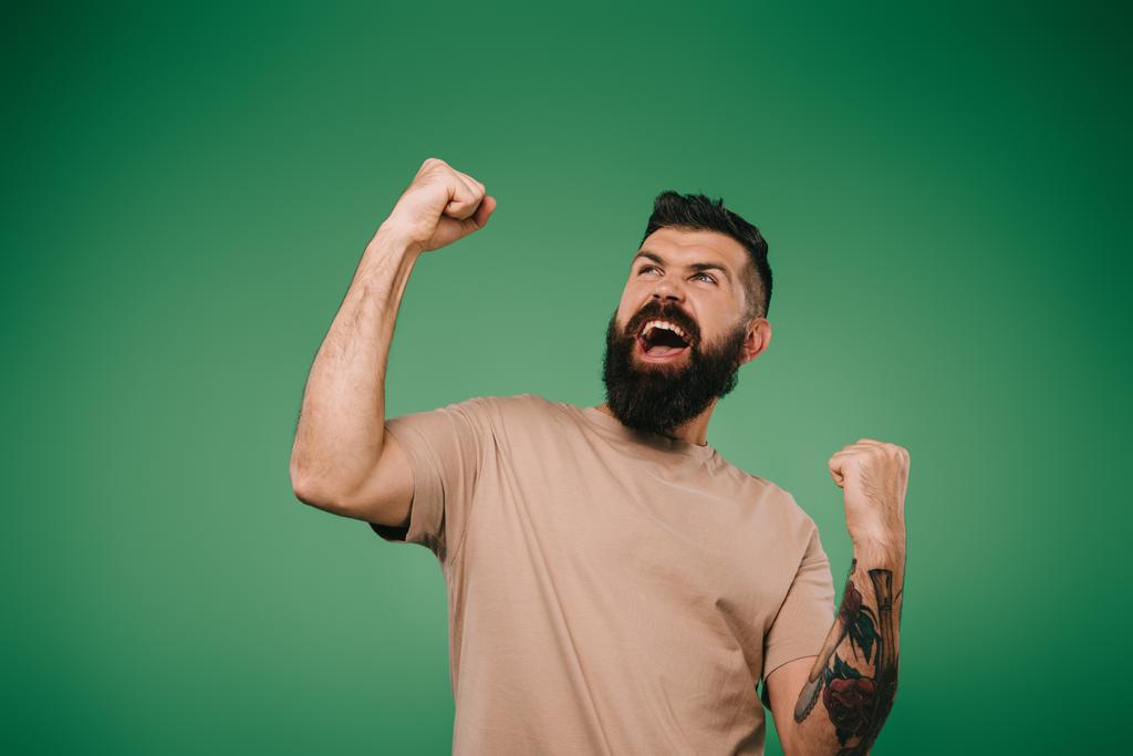ενθουσιασμένος γενειοφόρος άνδρας, χειρονομίες και φωνάζοντας απομονωμένη στο πράσινο - Φωτογραφία, εικόνα