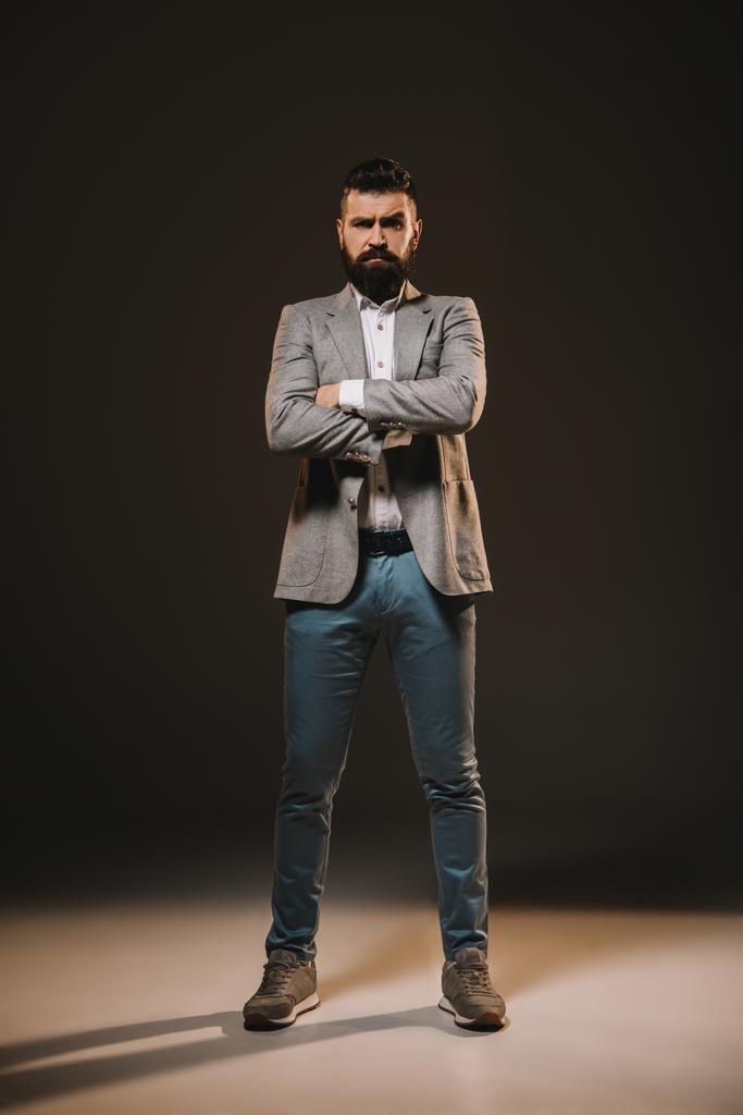 handsome businessman standing with crossed arms on brown - Photo, Image