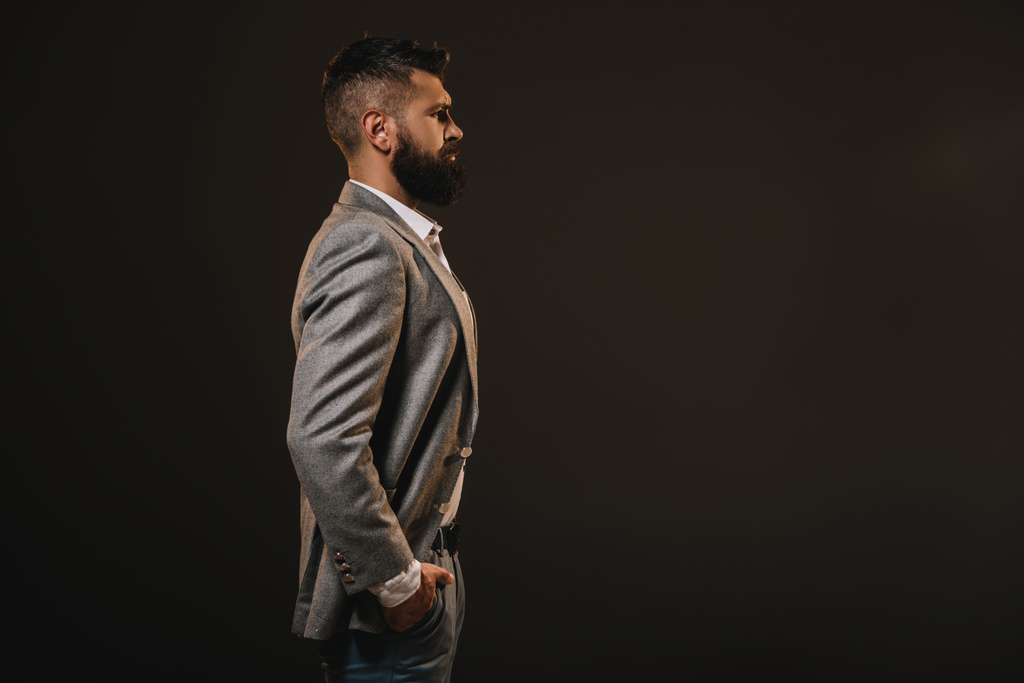 side view of beard businessman posing in gray jacket isolated on brown - Photo, Image