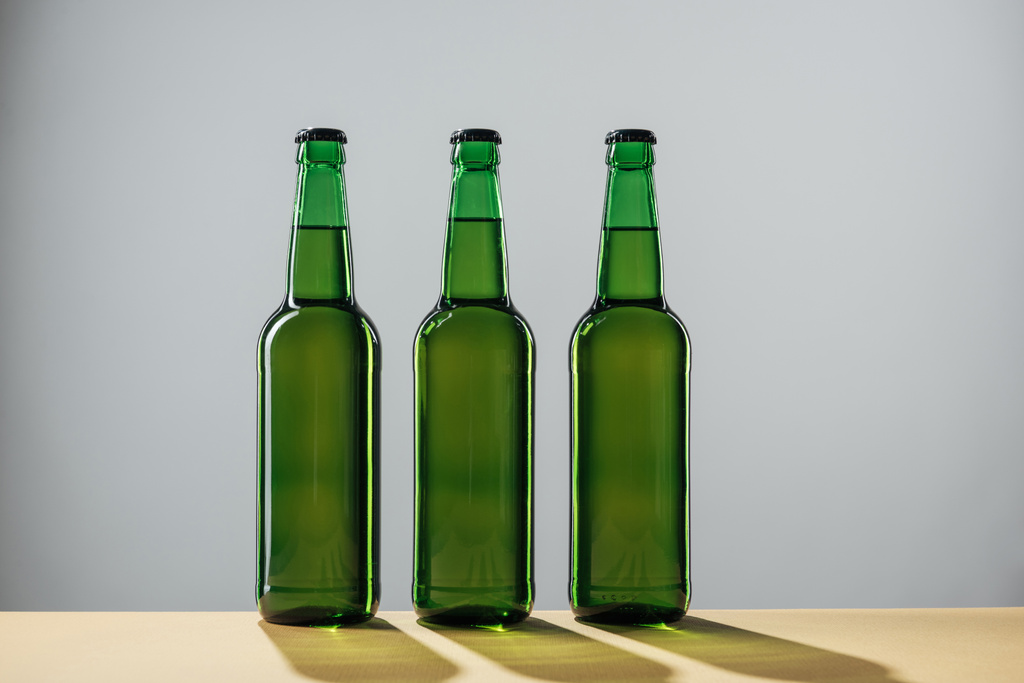 пляшки пива з тінями ізольовані на сірому, концепція дня святого патруля
 - Фото, зображення