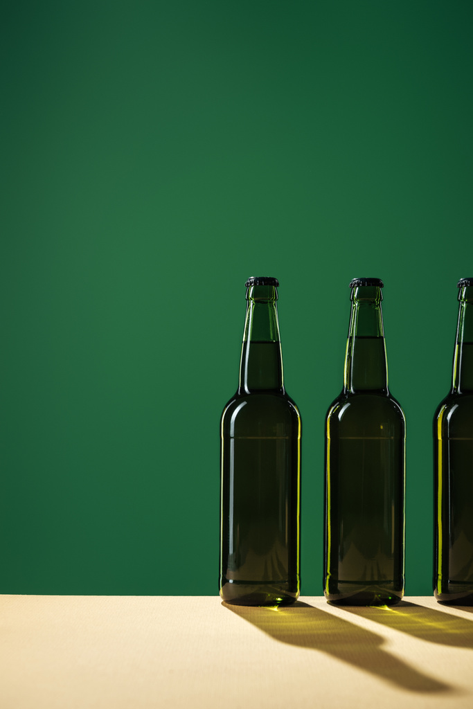 bouteilles de bière avec ombres et espace de copie isolé sur vert, concept st patrick jour
 - Photo, image
