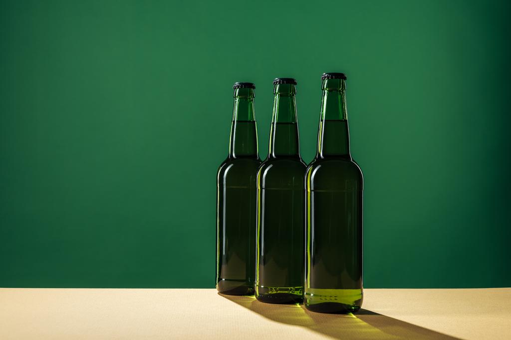 пивные бутылки с тенями и копировальным пространством, изолированные на зеленой концепции дня Святого Патрика
 - Фото, изображение