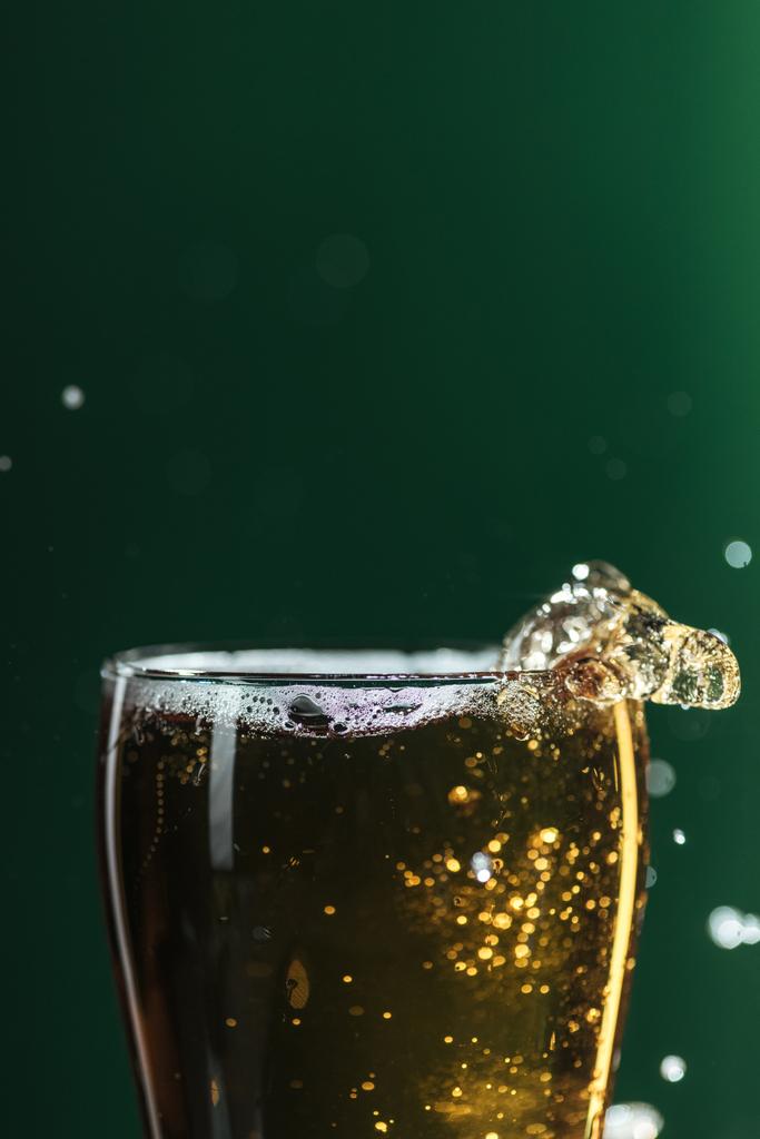 ποτήρι μπύρας με πιτσιλιές που απομονώνονται σε πράσινο με διάστημα αντίγραφο, απομονώνονται σε πράσινο - Φωτογραφία, εικόνα