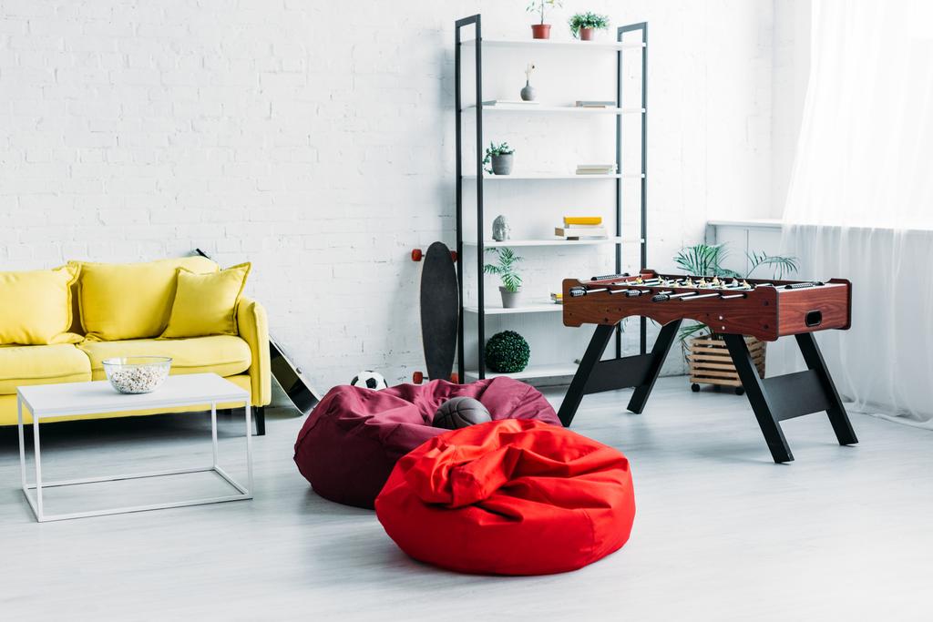 zařízený prostorný obývací pokoj s Pytlové křesla, pohovka a fotbalové tabulky - Fotografie, Obrázek