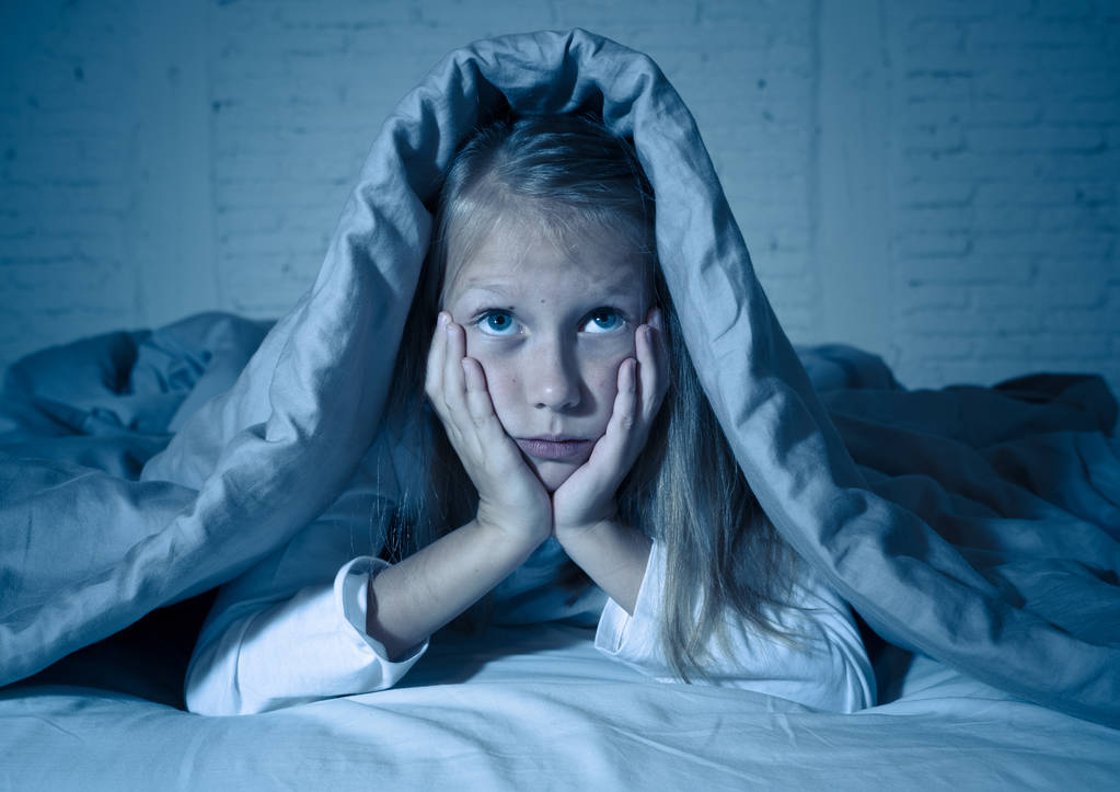 Schattig klein Kaukasische meisje liggend in bed die betrekking hebben op haar hoofd met deken gevoel uitgeput en slapeloze lijden aan slapeloosheid depressie Stress in emotionele kinderen en slaap stoornissen concept. - Foto, afbeelding