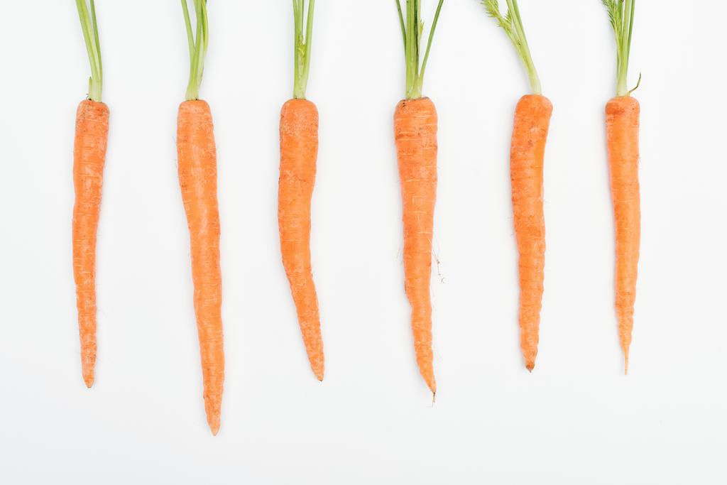 vista dall'alto di carote fresche mature crude disposte in fila isolate su bianco
 - Foto, immagini