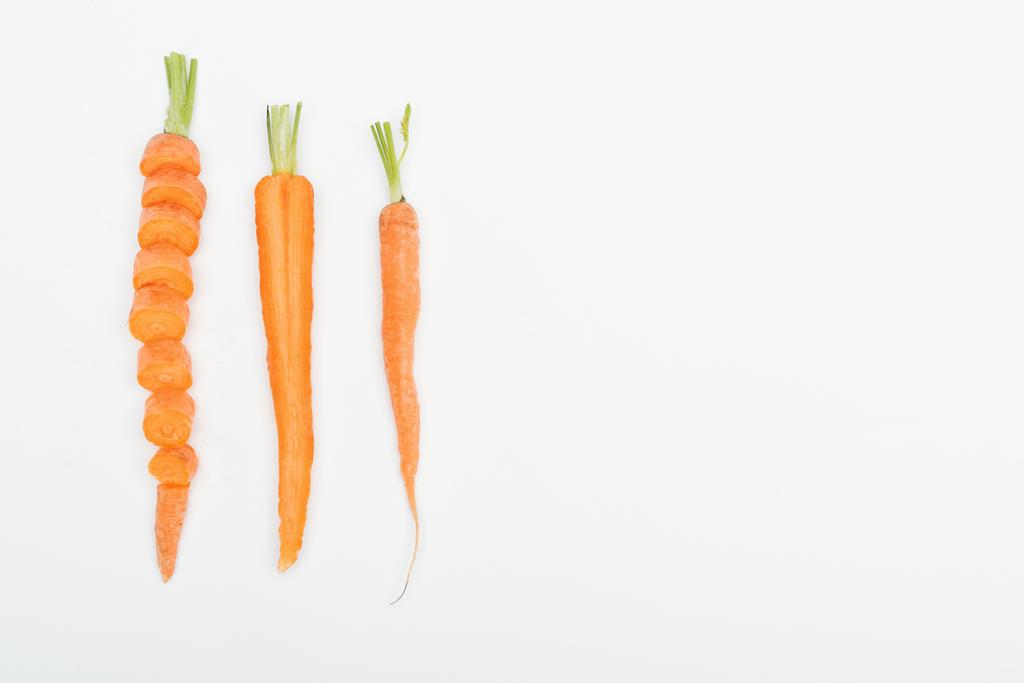 vista superior de zanahoria en rodajas, cortada y zanahorias enteras aisladas en blanco con espacio para copiar
 - Foto, imagen