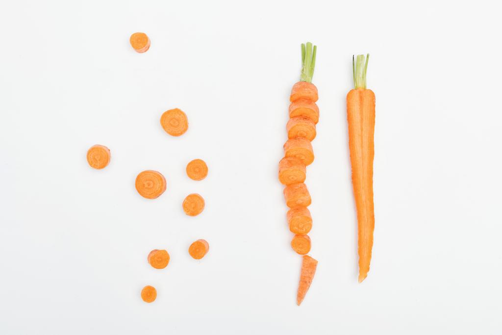 vista superior de fatias de cenoura, em fatias e cenouras cortadas isoladas em branco
 - Foto, Imagem