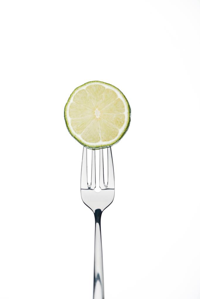 circle slice of fresh ripe juicy lime on fork isolated on white - Photo, Image