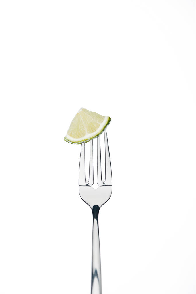 kwartaal segment van verse, sappige kalk op vork geïsoleerd op wit op wit wordt geïsoleerd - Foto, afbeelding