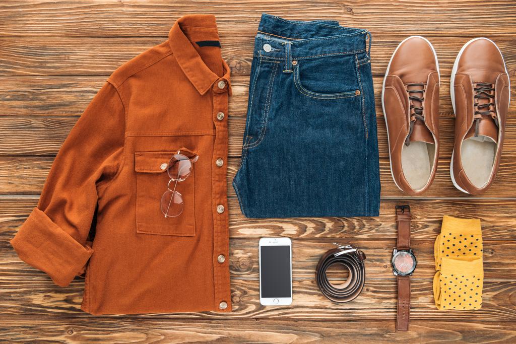 Flat lag met smartphone en mannelijke kleding op houten achtergrond - Foto, afbeelding