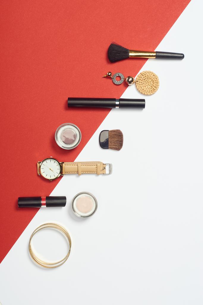 Flat lay with mascara, watch, bracelets, eyeshadow, lipstick, earring and cosmetic brushes - Photo, Image