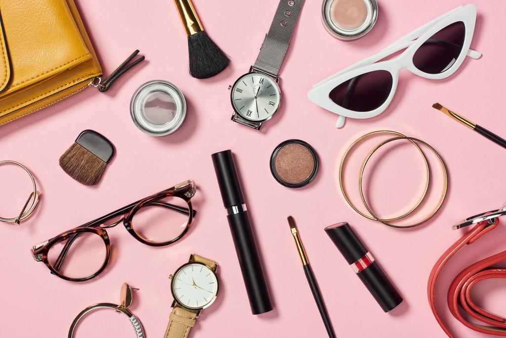 Top view of watches, lipstick, earrings, glasses, sunglasses, bag, eyesshadow, blush, belt, cosmetic brushes, bracelets and mascara
 - Фото, изображение