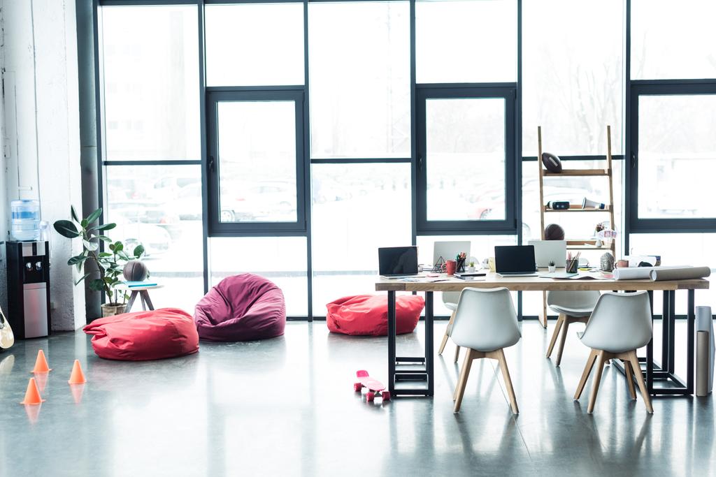современный дизайн просторного офиса на чердаке со стульями и столом с ноутбуками
 - Фото, изображение
