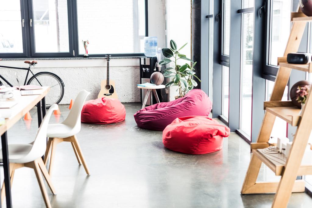 design moderno di spazioso ufficio soppalco con sedie sacchetto di fagioli, rack in legno e tavolo
 - Foto, immagini
