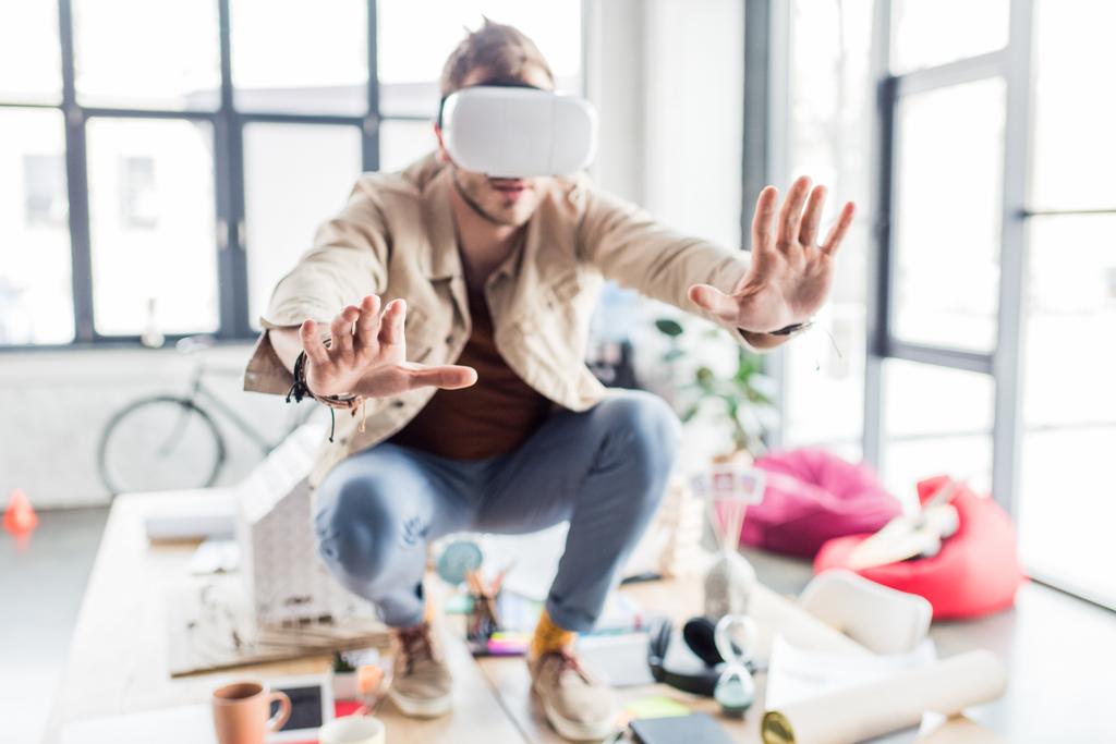 foco seletivo do designer masculino gestos com as mãos, tendo experiência realidade virtual no escritório loft
 - Foto, Imagem