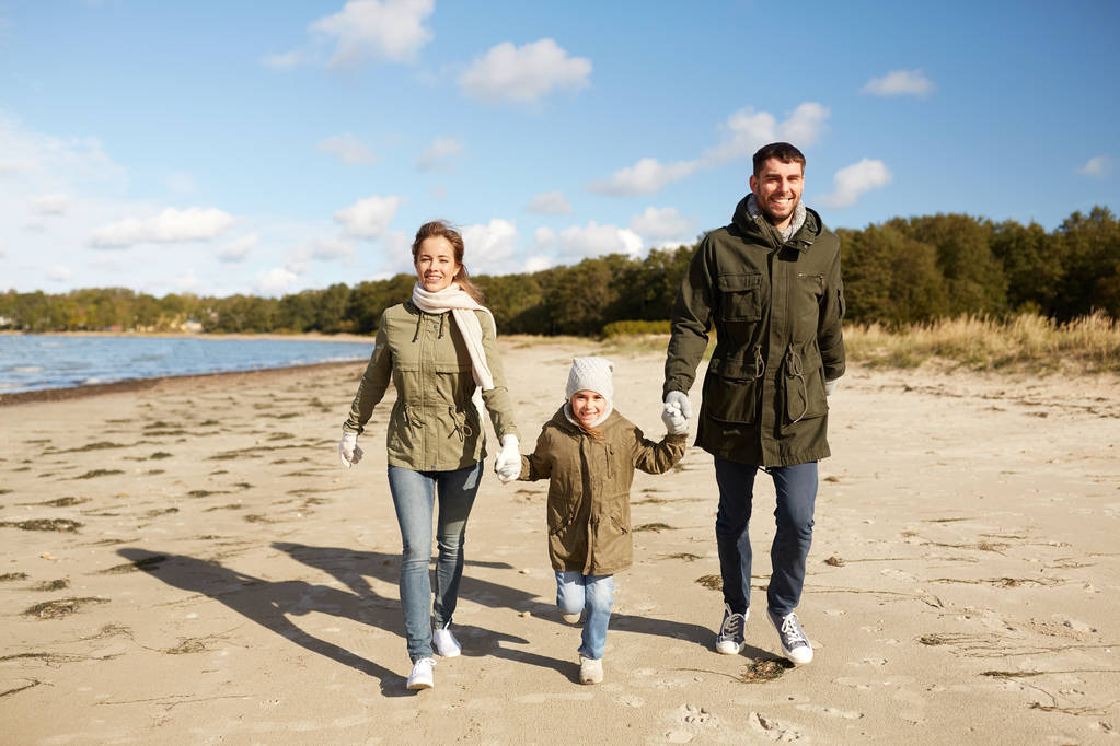 秋のビーチに沿って歩いて幸せな家族 - 写真・画像